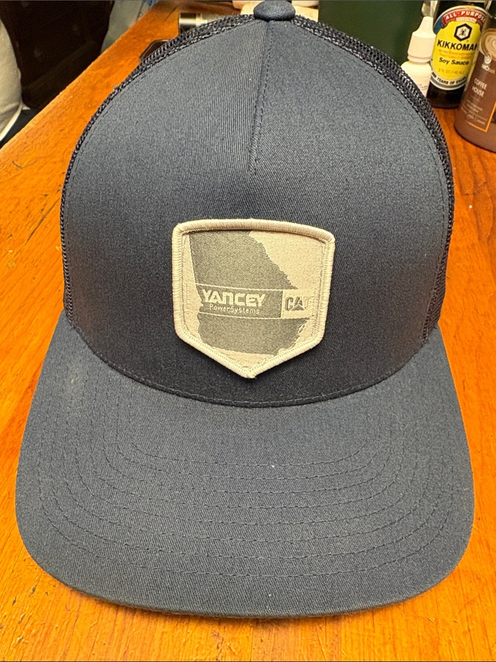 The Classic Yancey Bros Navy Trucker Hat with Beige Patch